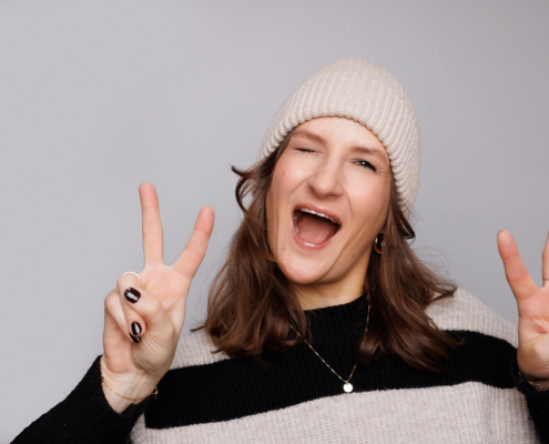 In 5 Schritten beeindruckenden LinkedIn-Posts mit Bildern - Joanna Gypser, Joanna4kids, Unternehmerin mit Mütze, 2 Finger nach oben