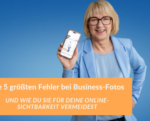 Fotografin in einem hellblauen Blazer lächelt und hält ein Smartphone mit einem Business-Foto in die Kamera, vor einem blauen Hintergrund. Textoverlay: „Die 5 größten Fehler bei Business-Fotos und wie du sie für deine Online-Sichtbarkeit vermeidest“.