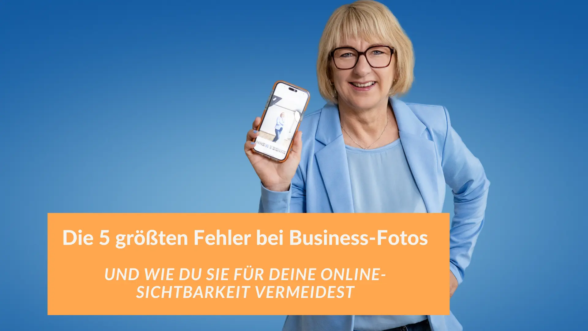 Fotografin in einem hellblauen Blazer lächelt und hält ein Smartphone mit einem Business-Foto in die Kamera, vor einem blauen Hintergrund. Textoverlay: „Die 5 größten Fehler bei Business-Fotos und wie du sie für deine Online-Sichtbarkeit vermeidest“.