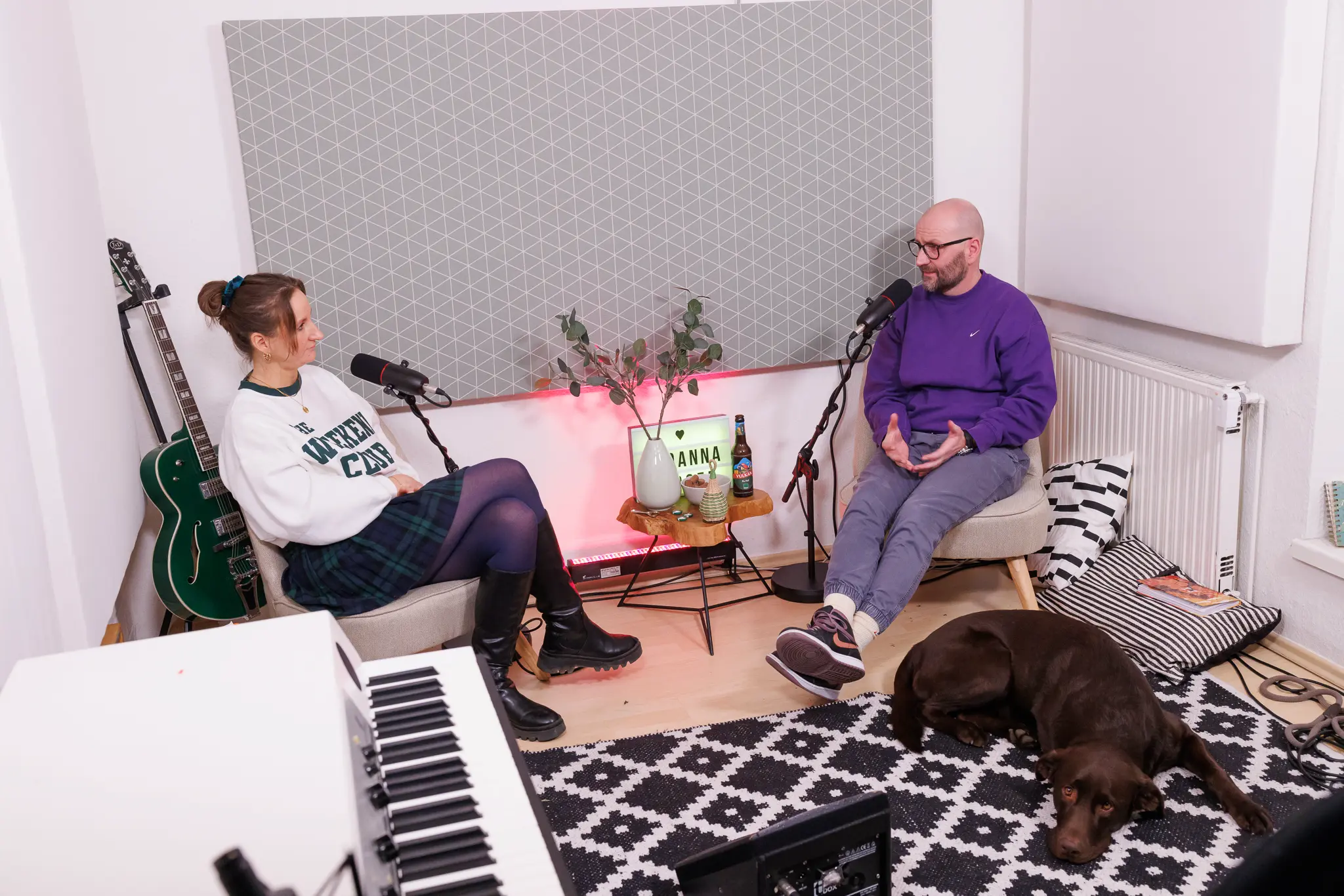 Blick auf Joanna Gypser und Christian Schmidt im Gespräch. Kuba liegt zwischen den beiden, während das Tiny Studio gemütlich eingerichtet ist.