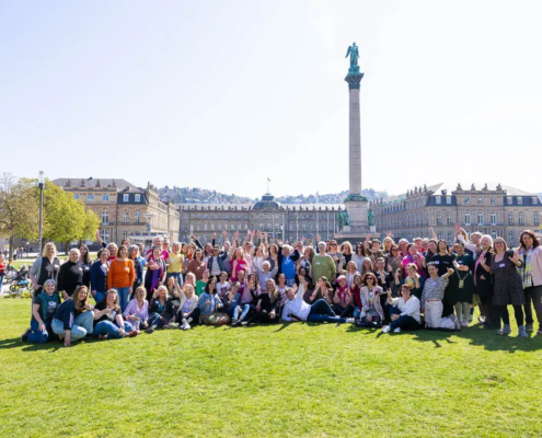 tcs-barcamp-2025-gruppenfoto-schlossplatz-stuttgart.jpg Gruppenfoto von rund 90 Teilnehmer:innen des The Content Society Barcamp 2025 auf dem Schlossplatz in Stuttgart. Die Gruppe steht und sitzt auf der Wiese, alle jubeln und winken in die Kamera. Im Hintergrund das Neue Schloss und die Jubiläumssäule bei strahlendem Sonnenschein.