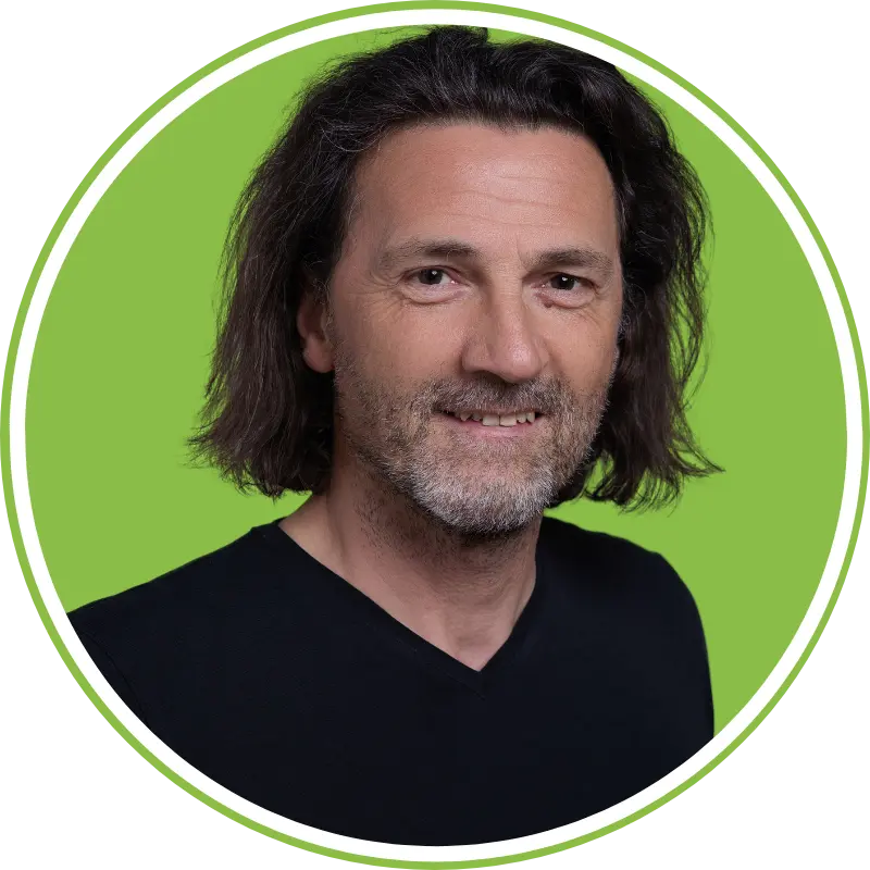 Professionelles LinkedIn-Portrait eines Mannes mit grünem Branding-Hintergrund und natürlichem Ausdruck.