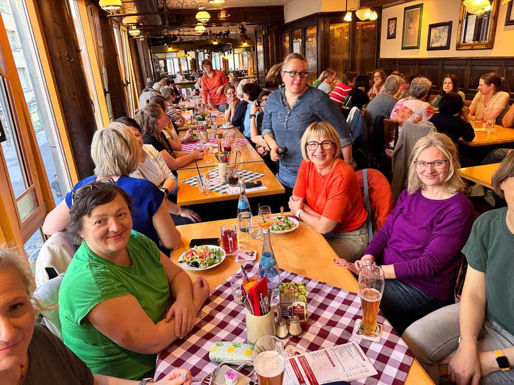 Teilnehmerinnen des The Content Society Barcamps 2025 beim gemeinsamen Abendessen in Sophies Brauhaus in Stuttgart. Die Stimmung ist lebendig und herzlich. Langes Holzbankett mit fröhlichen Gesprächen, Getränken und bayerischer Deko.