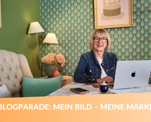 Karina Schuh sitzt mit Laptop in farbenfroher Umgebung und lädt zur Blogparade „Mein Bild – meine Marke