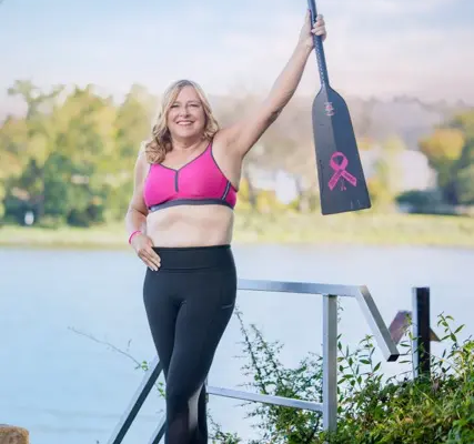 Thea - Pink Paddlerin mit dem Paddel nach oben Thea - Pink Paddlerin im pinkfarbenen Sport-BH der Firma Anita. Sie hält das Paddel nach oben und fühlt sich schön und stark.