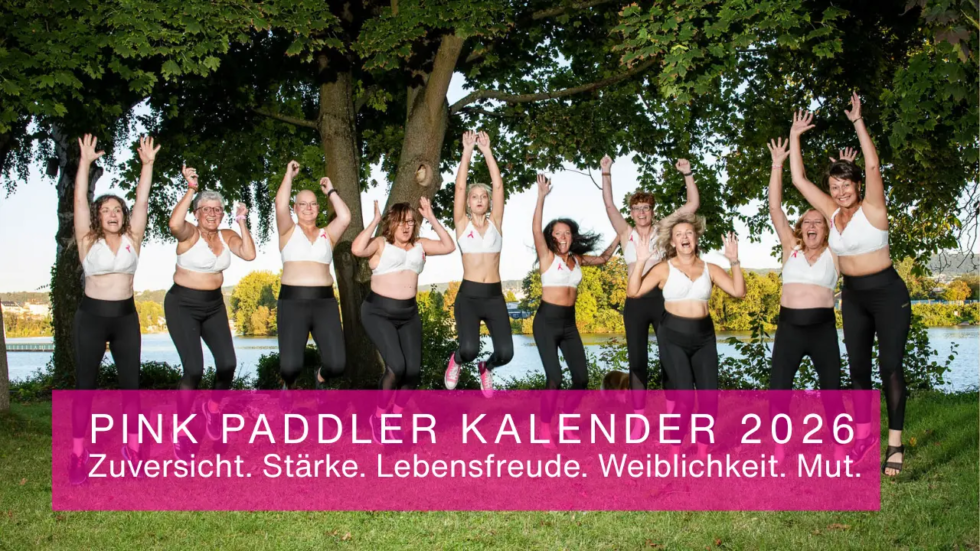 Kalender 2026 - Zehn Frauen der Pink Paddler in weißen BH's der Firma Aubade Paris und Sporthosen von La Mesma springen in die Luft - Symbolbild für Stärke, Zusammenhalt und Sichtbarkeit.