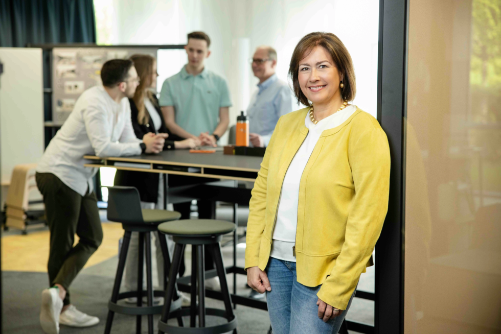 Unternehmerin Nieke Arendt, fotografiert von Karina Schuh, steht vor ihrem Team in modernen Büroräumen. Personal Branding Fotoshooting für Unternehmen und Führungskräfte – authentische Businessfotografie mit Teambezug und Markenwirkung.